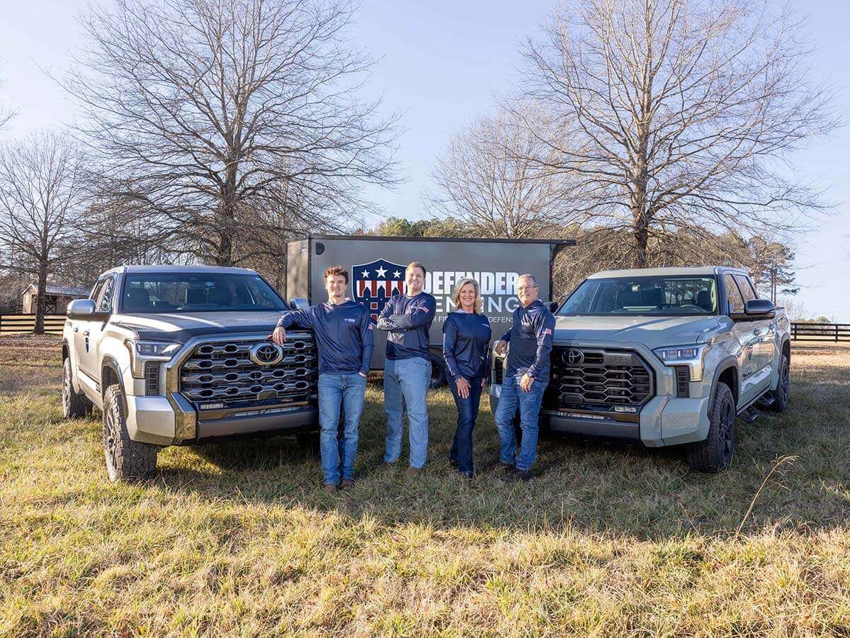 Defender Fencing team with company trucks providing residential and commercial fencing